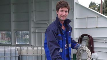 Thomas Arndt (23) mit einem Tau an Bord eines Fährschiffes