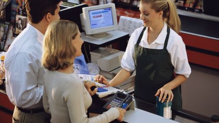 Young couple standing at the checkout counter in a supermarket