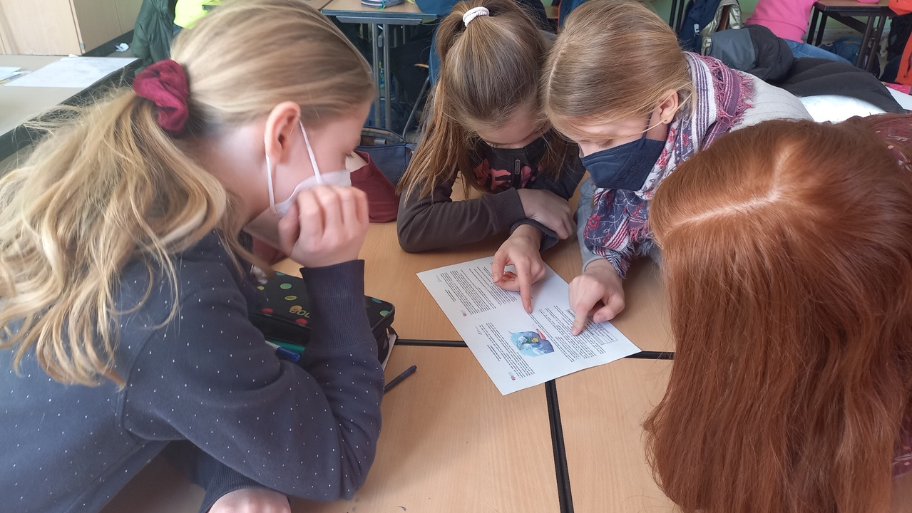 Foto aus dem Projekt "Mathe im Advent": vier Schülerinnen lösen gemeinsam eine Matheaufgabe