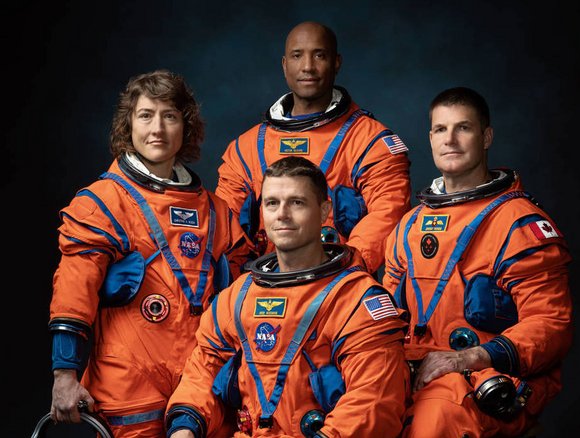 Vier Personen in Astronautenanzügen.