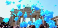 Blaue Luftballons steigen vor dem Brandenburger Tor in den Himmel