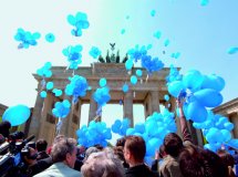 Blaue Luftballons steigen vor dem Brandenburger Tor in den Himmel