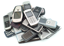 Alte Handys liegen auf einem Haufen.