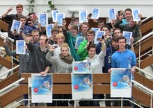 Schüler eines Gymnasiums stehen auf einer Treppe und zeigen Plakate und Flyer der Rohstoff-Expedition.