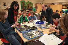 Schüler einer Klasse in Gießen zerlegen Handys. An der Unterrichtsstunde nimmt der Parlamentarischer Staatssekretär Dr. Helge Braun teil.