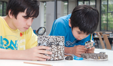 Kinder experimentieren an Bodenteilen