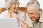 Ältere Frau und älterer Mann arbeiten am Laptop