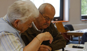 Zwei Senioren testen zusammen die Smartphones