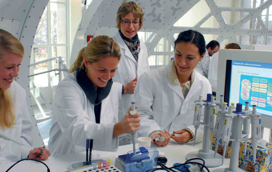 Besucherlabor: Mehrere Personen stehen im Labor und experimentieren.