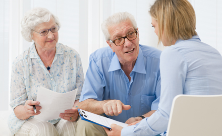 Eine junge Frau berät ein älteres Paar