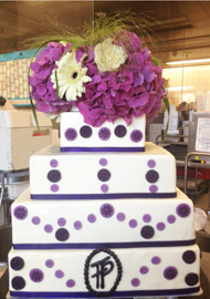 Eine dreistöckige weiß und violett verzierte Torte.