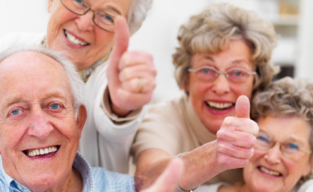 Zwei ältere Männer und zwei ältere Frauen lachen in die Kamera