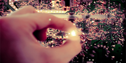 eine hand hält etwas leuchtendes vor einem computerchip