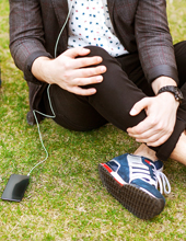 Ein junger Mensch sitzt auf der Wiese.