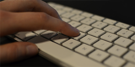 Hand tippt auf Tastatur