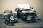 Altes Telefon neben Schreibmaschine