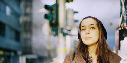 Eine junge Frau, im Hintergrund ist eine Kreuzung