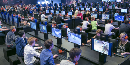 Viele Menschen sitzen vor Computern und spielen.