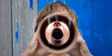 Ein junger Mann ruft in ein Sprachrohr