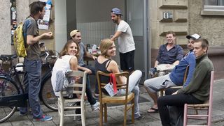 Junge Menschen sitzen an einem Tisch in der Rudolfstraße
