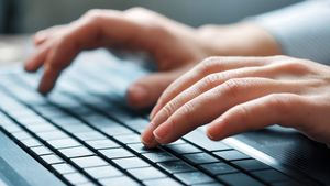 Hände tippen auf einer Tastatur