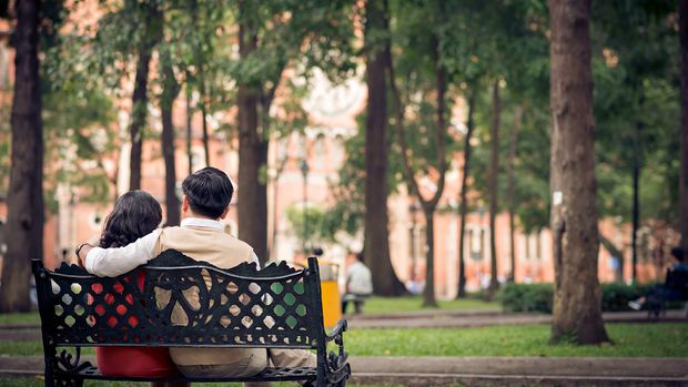 Ein Paar sitzt auf einer Bank in einem Park.