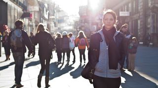 Junge Frau in belebter Fußgängerzone