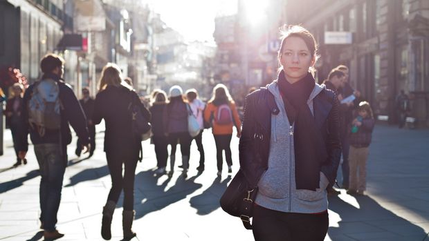 Junge Frau in einer belebten Fußgängerzone