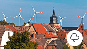 Windräder über den Dächern einer Stadt