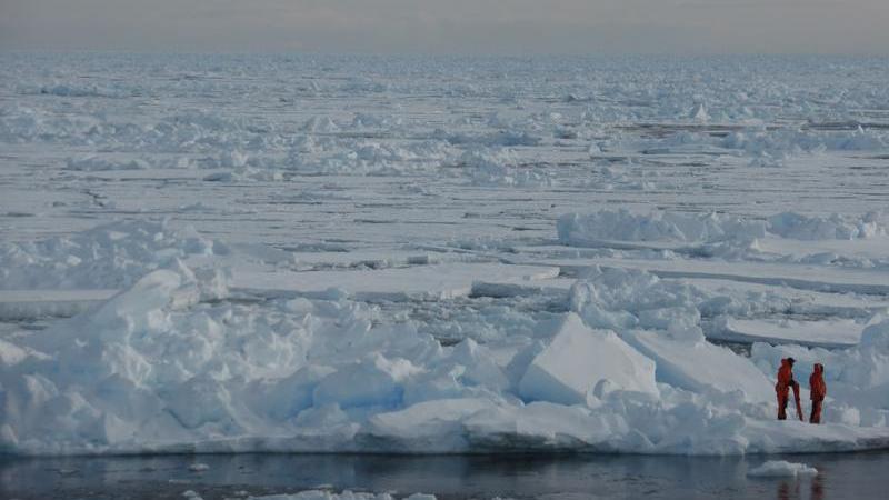 Foto, das Forscher auf arktischem Eis beim Erkunden der Folgen des Klimawandels zeigt