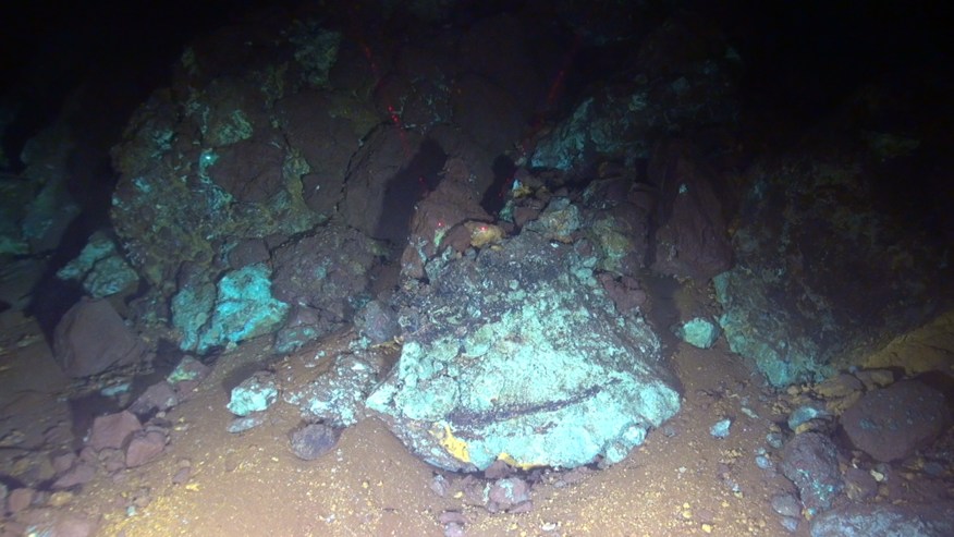 Photo showing copper-rich (green) mineralisation on the seafloor (3600m) in our study area (26°N MAR).