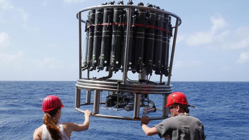 Foto eines Kranzwasserschöpfers, welches vom Forschungsschiff METEOR aus ins Wasser gelassen wird