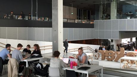 Foto des Kulturzentrums „Dokk1“ in Århus, bevölkert von Studenten und Lerngruppen.