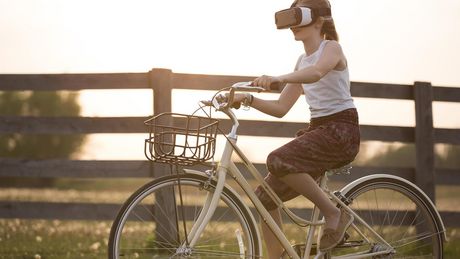 Foto eines radfahrenden Mädchens mit VR-Brille