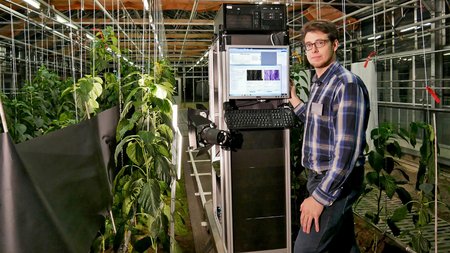 Marvin Krüger, Mitarbeiter am Julius Kühn-Institut, demonstriert den mobilen Messstand zur Analyse des Gesundheitszustands von Paprikapflanzen. © Mariska Schäffer/HortiCo 4.0