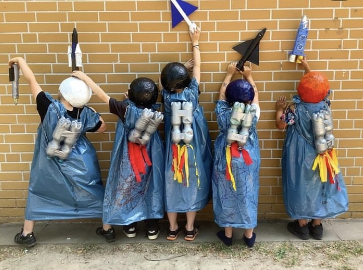 Kinder in selbstgebastelten Kostümen mit Raketen auf dem Rücken