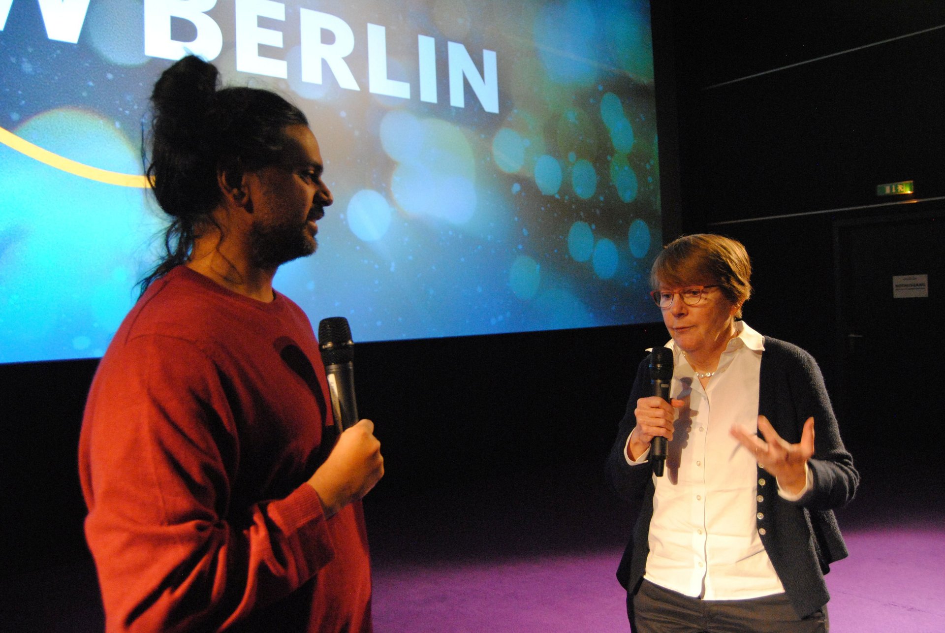 Foto von zwei Menschen auf einer Bühne.