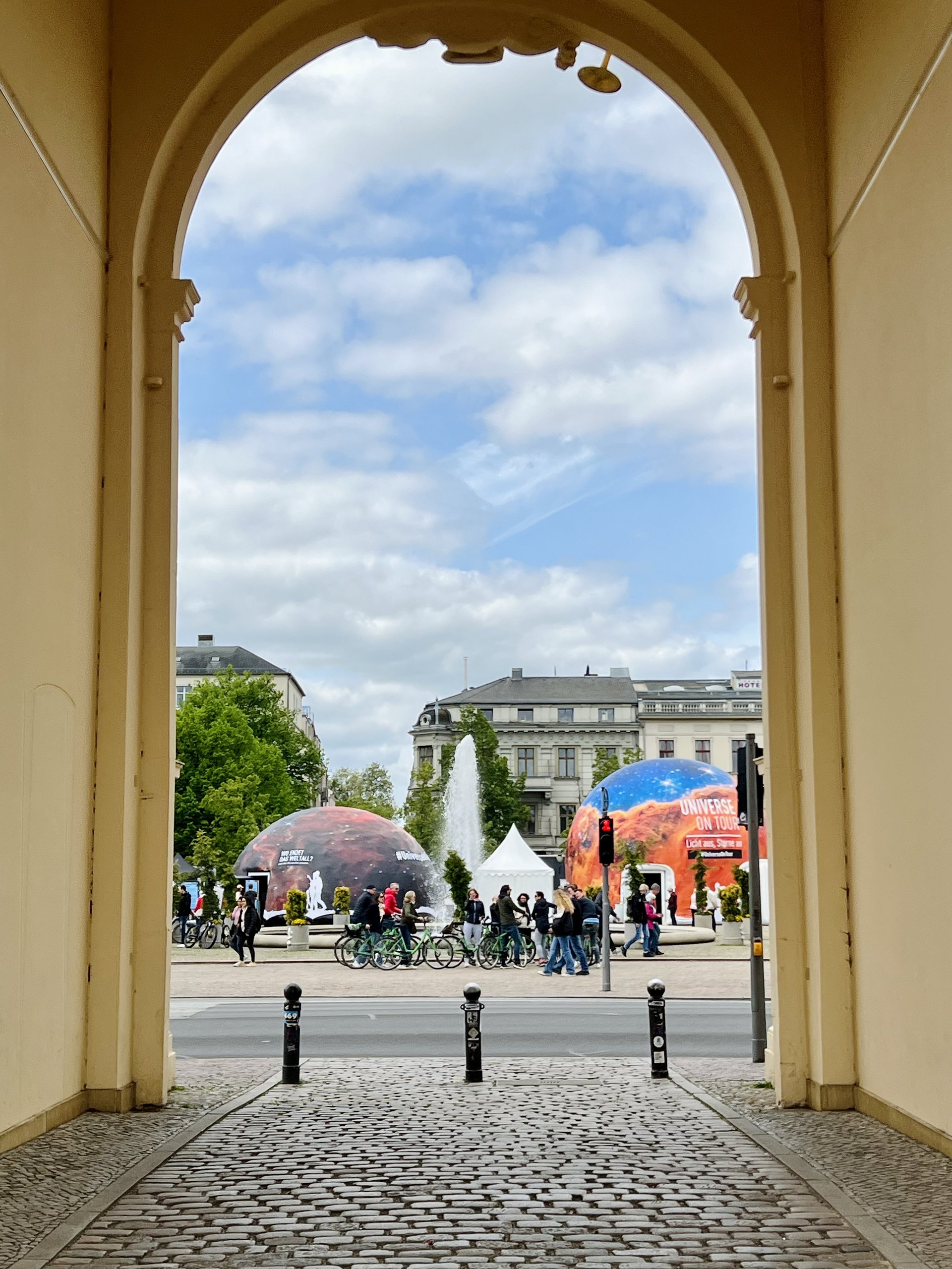 Foto vom Planetariumszelt in der Ferne, die fotografierende Person steht unter einem Torbogen