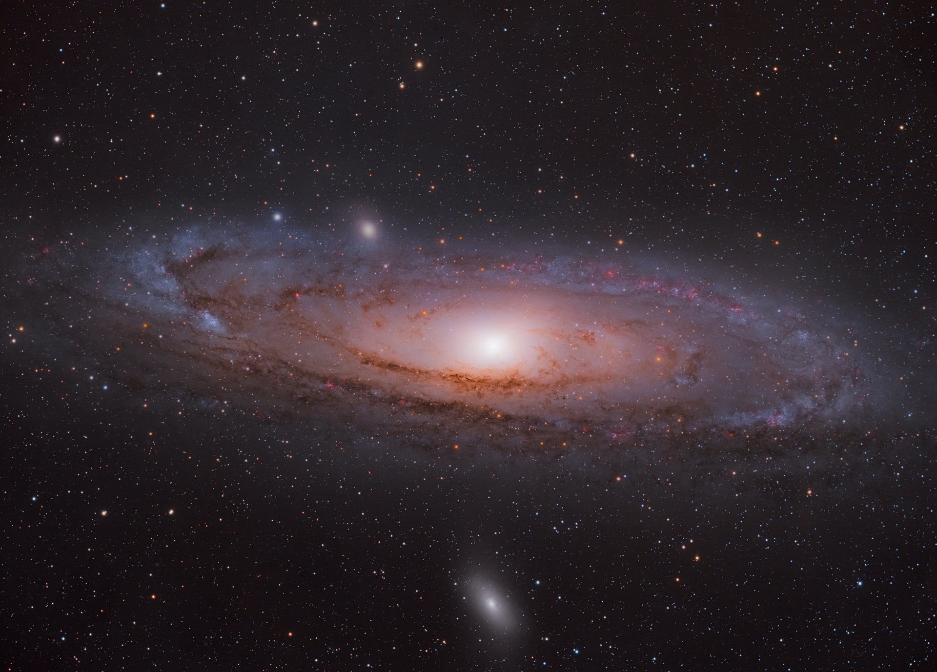 Eine strudelartige rosa Galaxie im Universum umgeben von Sternen.