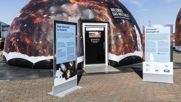 Ein aufblasbares Zelt mit zwei Ausstellern davor.