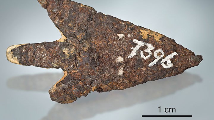 Ein Stück rostiges Eisen in Pfeilform, darauf ist in weiß die Zahl 7396 geschrieben. 