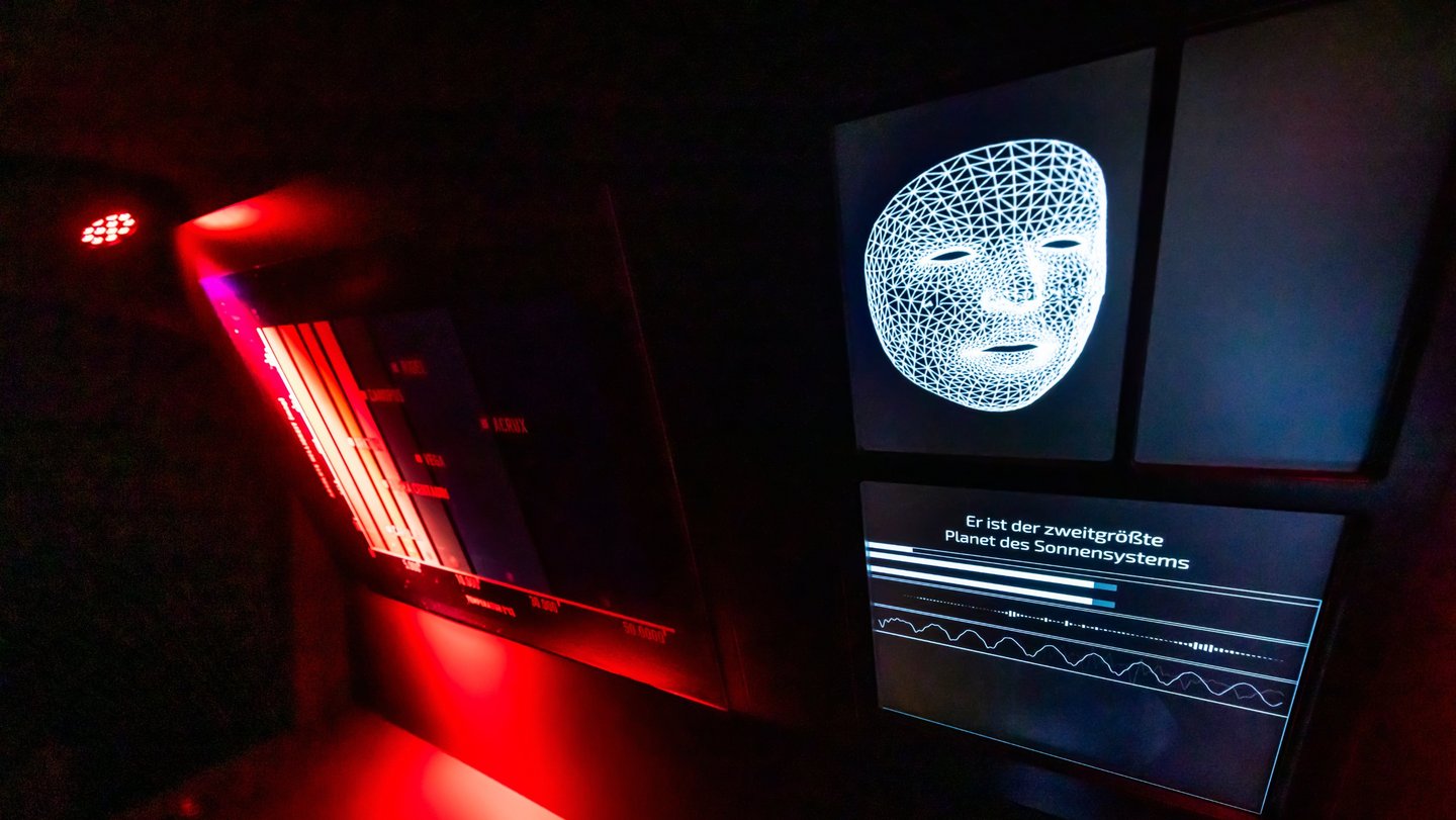 Ein Bildschirm zeigt ein Bild einer weißen Maske in einem dunklen Raum