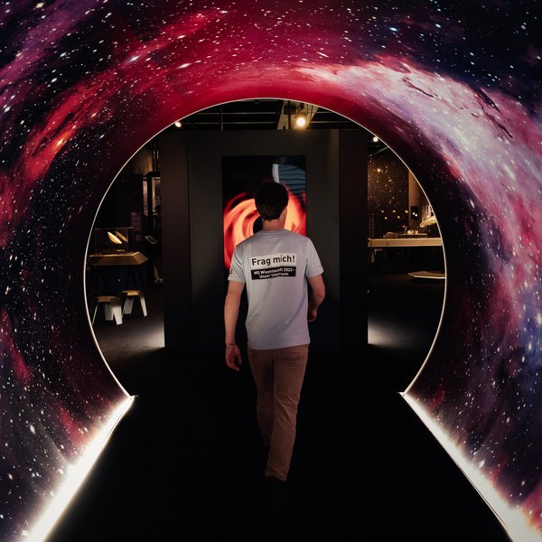 Eine Person läuft durch einen Tunnel mit Weltraumaufdruck in der Ausstellung