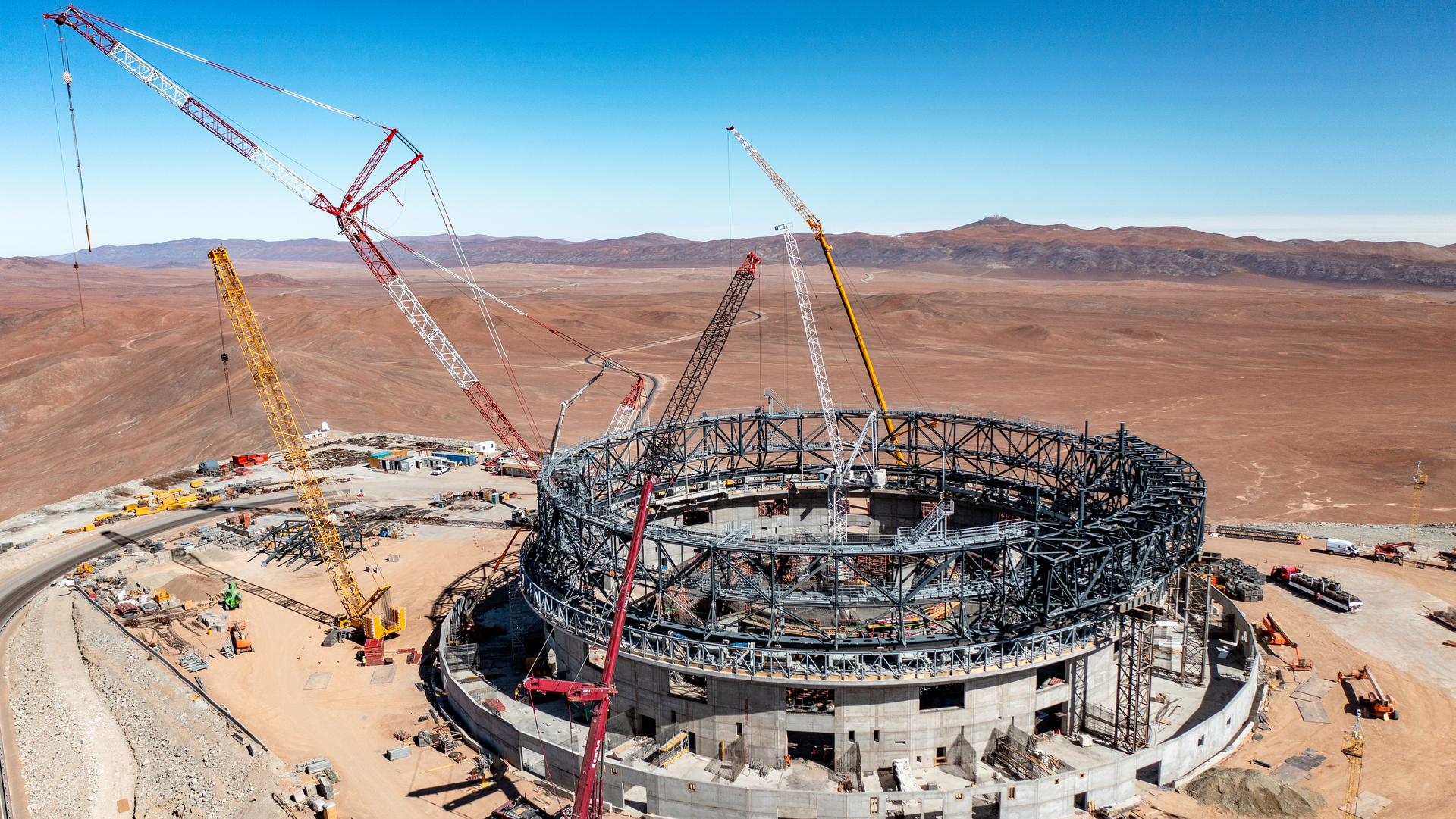 Eine Baustelle in der Wüste mit einem Gerüst, das auf einem großen, runden Fundament steht