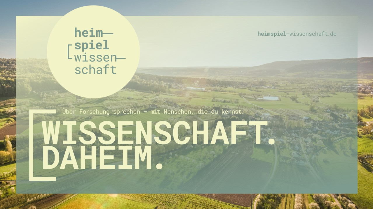 Logo Heimspiel Wissenschaft: ein Foto einer Landschaftsaufnahme, darüber ist ein Layer gelegt, in dem "heimspiel wissenschaft" und "WISSENSCHAFT. DAHEIM" steht. 