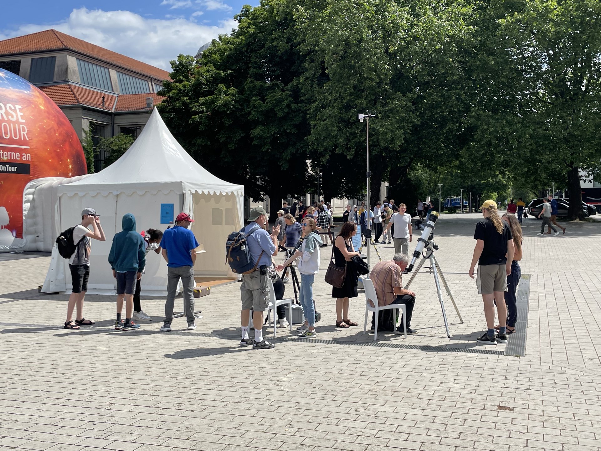 Besuchende schauen durch ein Teleskop in den Himmel