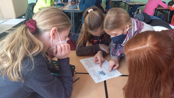 Foto aus dem Projekt "Mathe im Advent": vier Schülerinnen lösen gemeinsam eine Matheaufgabe