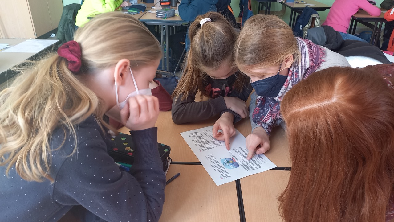 Foto aus dem Projekt "Mathe im Advent": vier Schülerinnen lösen gemeinsam eine Matheaufgabe