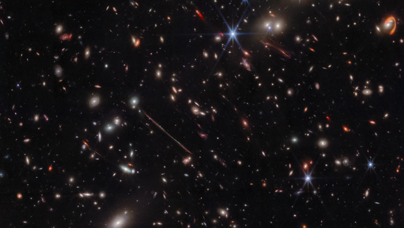 Ein dunkler Hintergrund mit vielen verschwommenen Flecken darauf. In der Mitte ist eine blasse Linie, rechts oben ein knalloranger, hakenförmiger Bogen