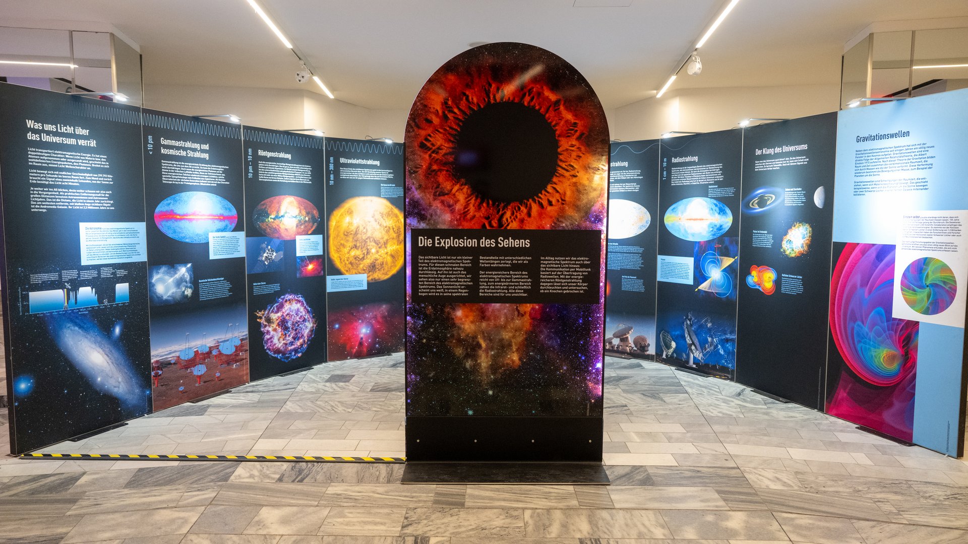 Foto von Stellwänden, auf denen Informationen und Bilder über das Universum zu sehen sind.